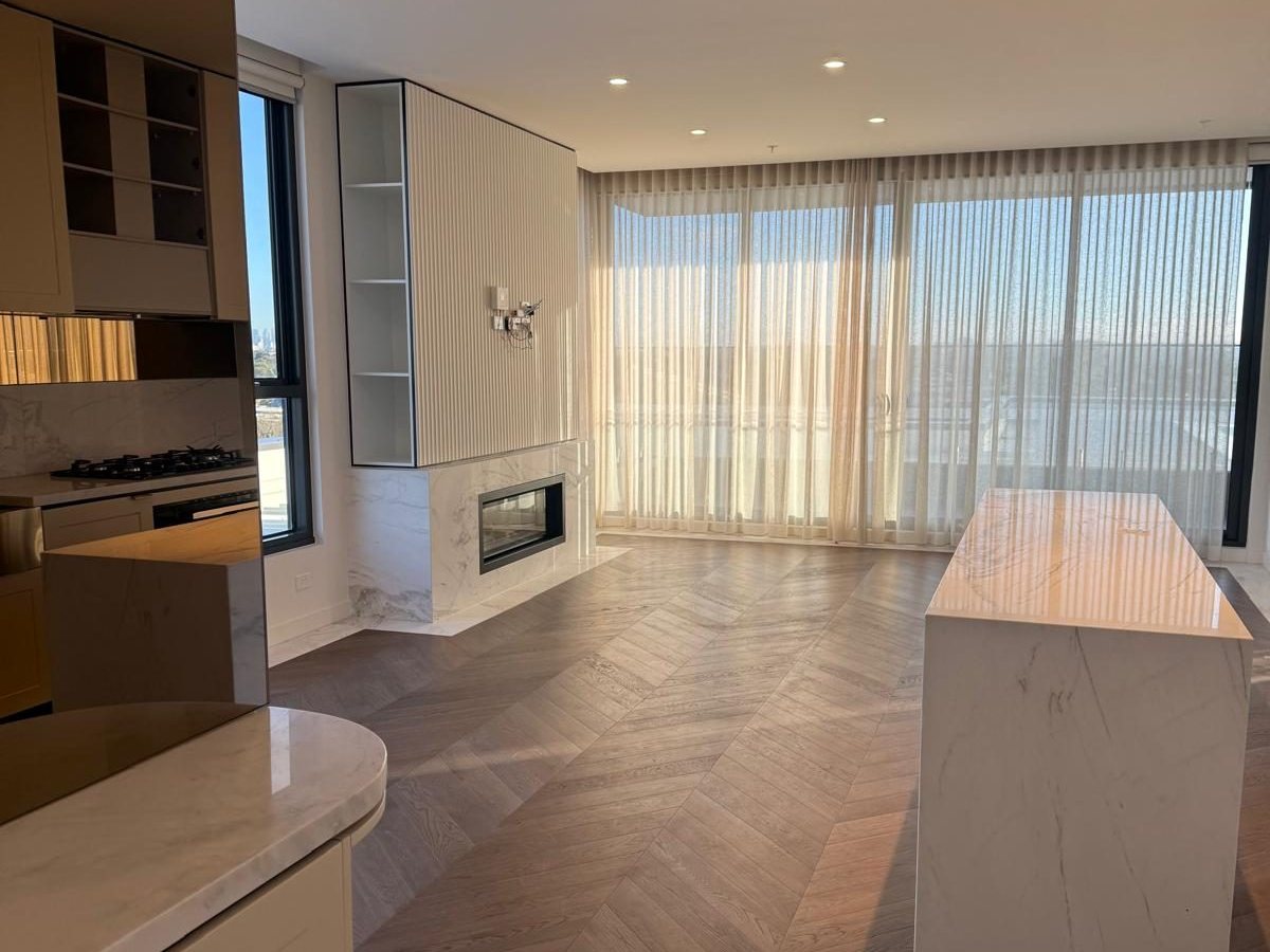 Apartment living and kitchen area after an Ocean Bright clean — herringbone floors, spotless stone benchtops and streak-free glass.