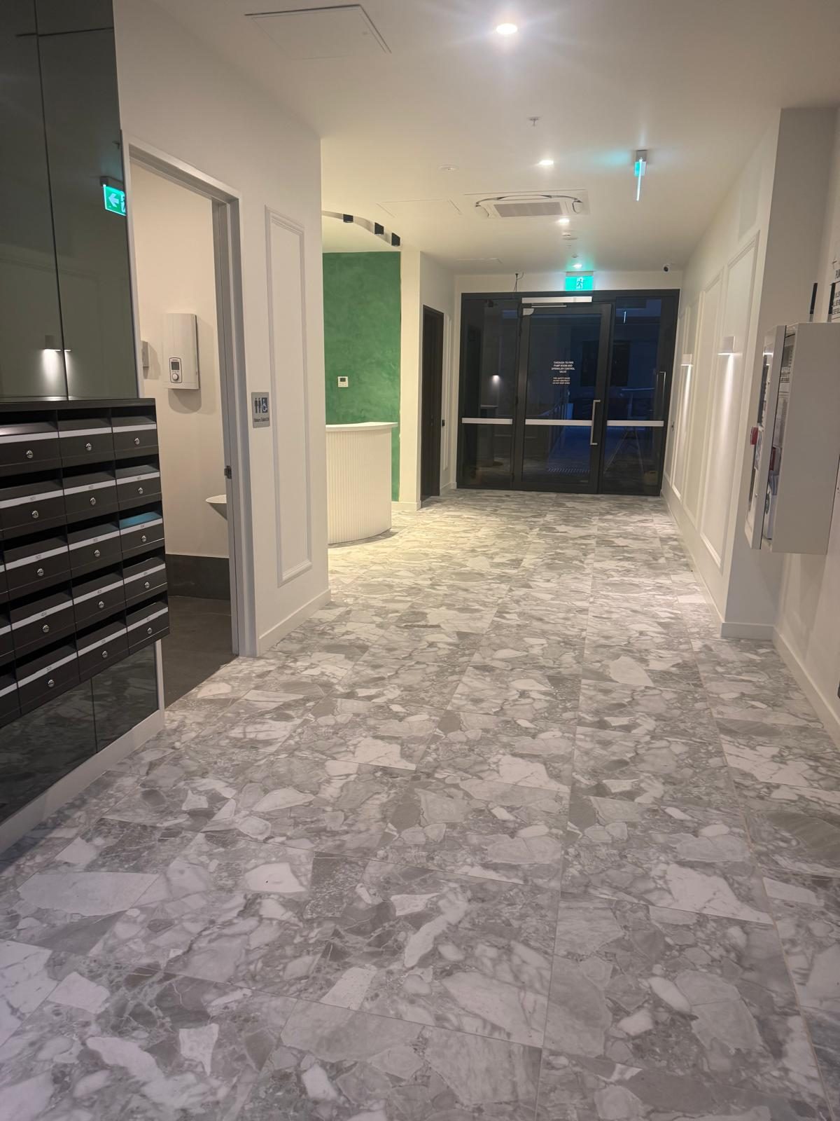 Mail room and entry area with spotless floors and glass