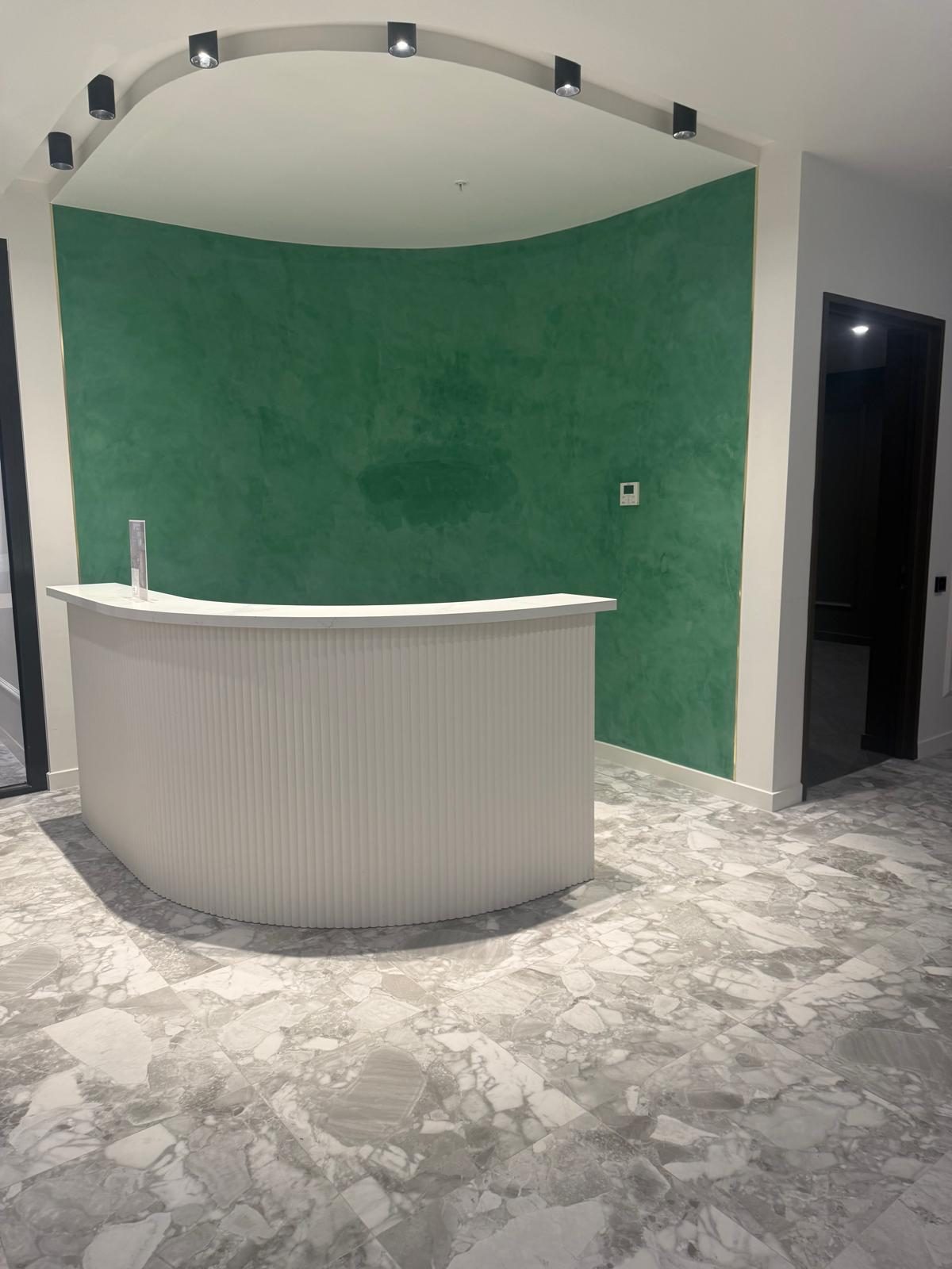 Apartment building reception with polished stone floors and a clean feature wall